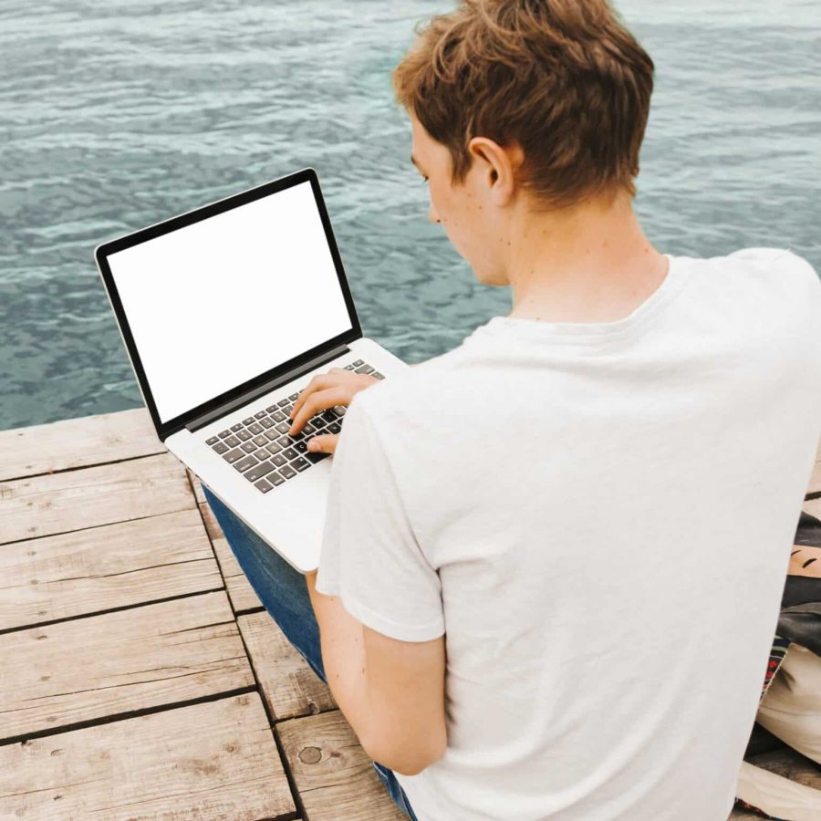 jeune-homme-aide-ordinateur-portable-au-bord-eau.jpg